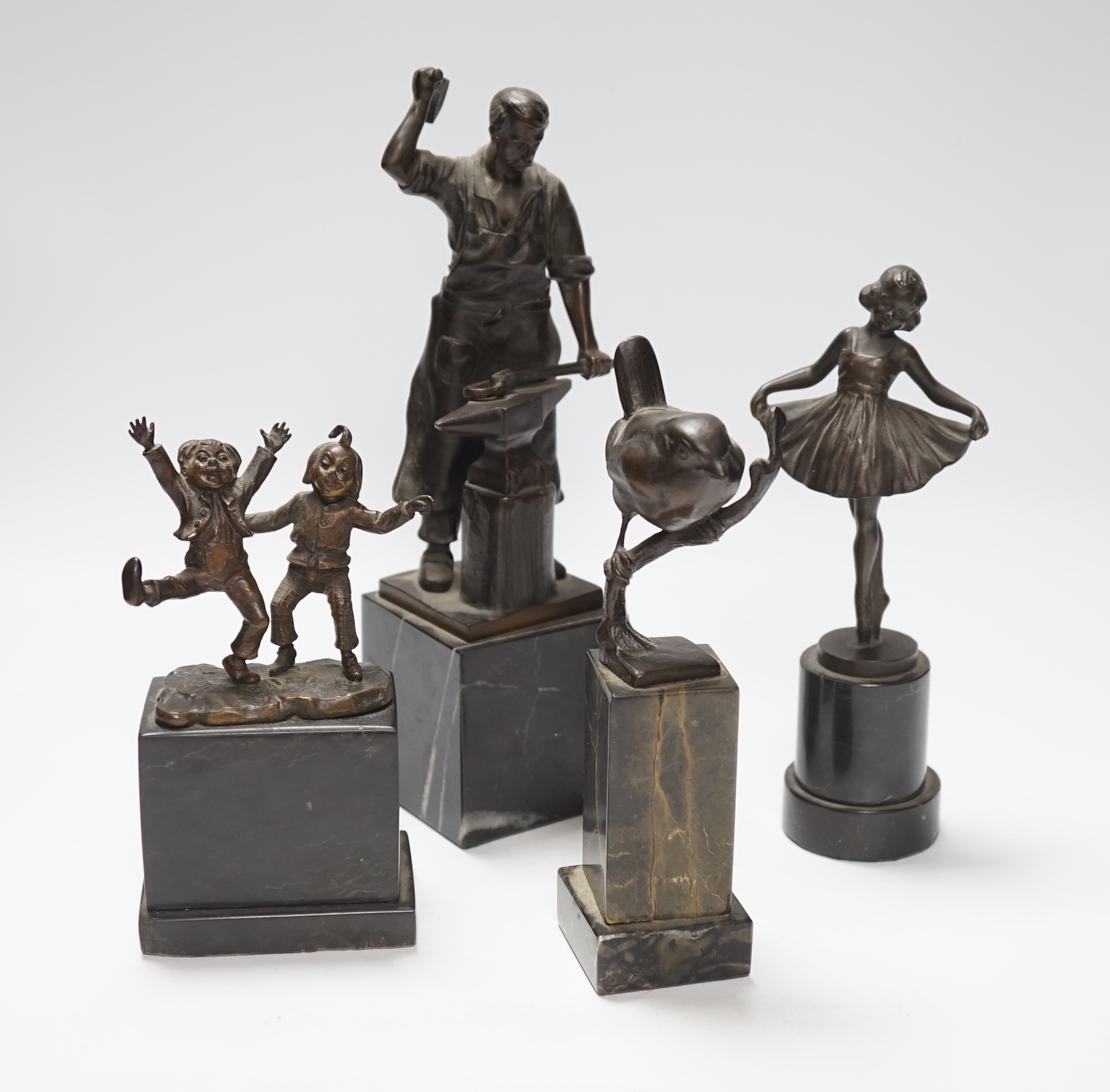 A German bronze of a blacksmith, indistinctly signed, a bronze figure group signed Öbold, a bronze of a Robin, signed K. Reynen and an unsigned bronze of a ballerina, all on marble bases, tallest 27cm (4)